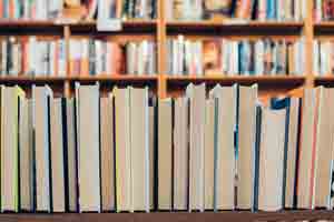 Books on a shelf with the spines facing away.