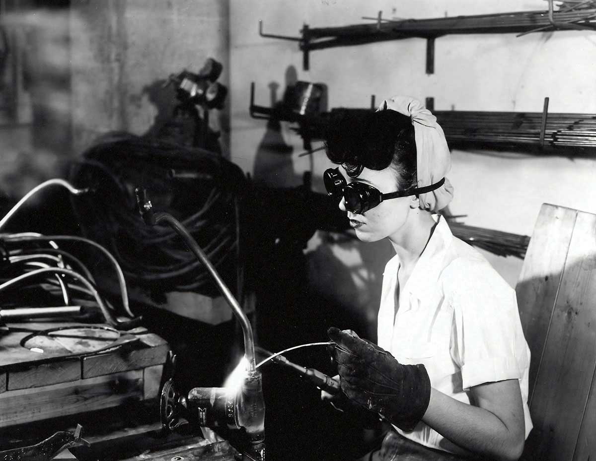 Black and white photo of a woman in WW2 welding.