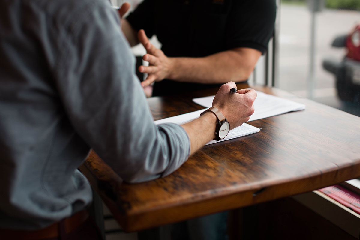 Two people sitting at a table talking.